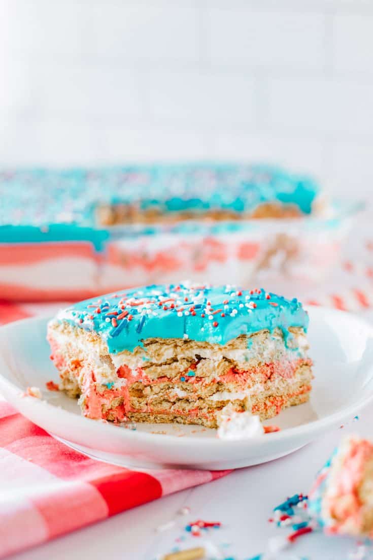 A slice of red, white and blue no-bake American flag icebox cake on a plate ready to be served.