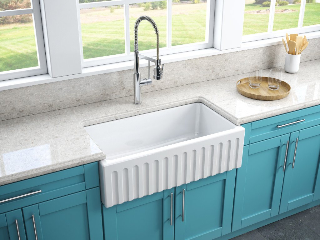 A clean kitchen counter with a kitchen sink empty of all dishes. 