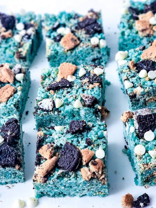 Blue cookie monster rice crispy treats topped with crumbled cookies and white chocolate chips. 