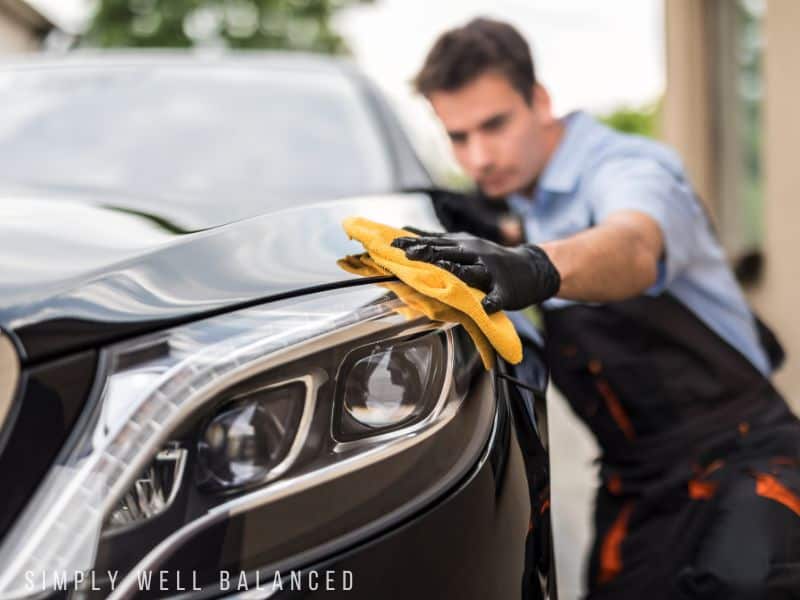 Man drying a car after finishing a car detail service. Paying to get someone\'s car detailed is a great gift idea for a woman who thinks she doesn\'t want anything. 