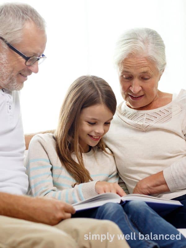 A young girl reads to elderly adults. 