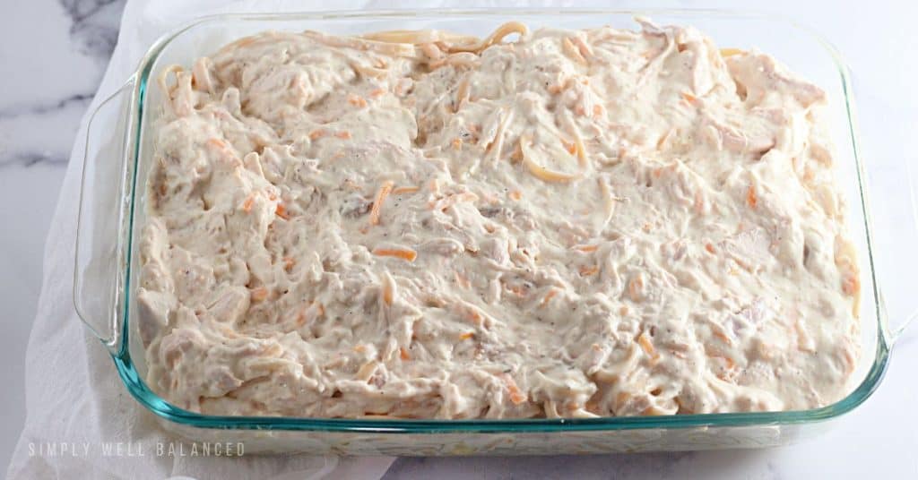 Creamy chicken tetrazzini mixture in a glass 9x13 casserole dish. 