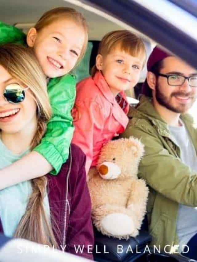  A family of four loaded up in the car, getting ready to go on a summer road trip. 