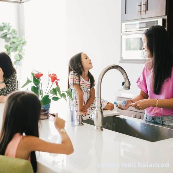 A mom enjoying motherhood in the kitchen with her kids. 