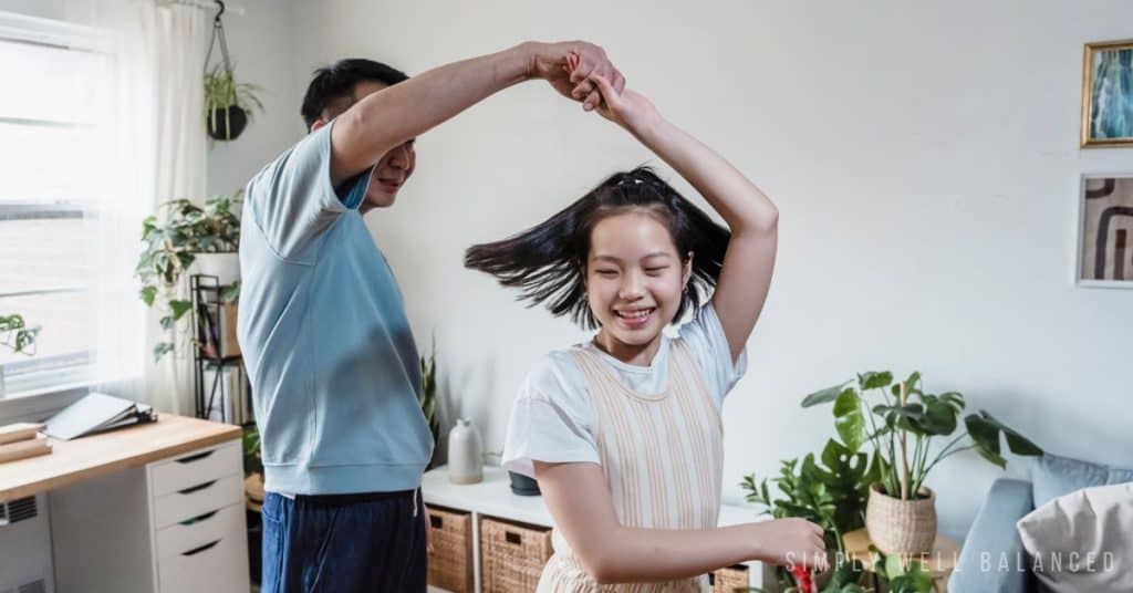Father and teen daughter dancing together. 