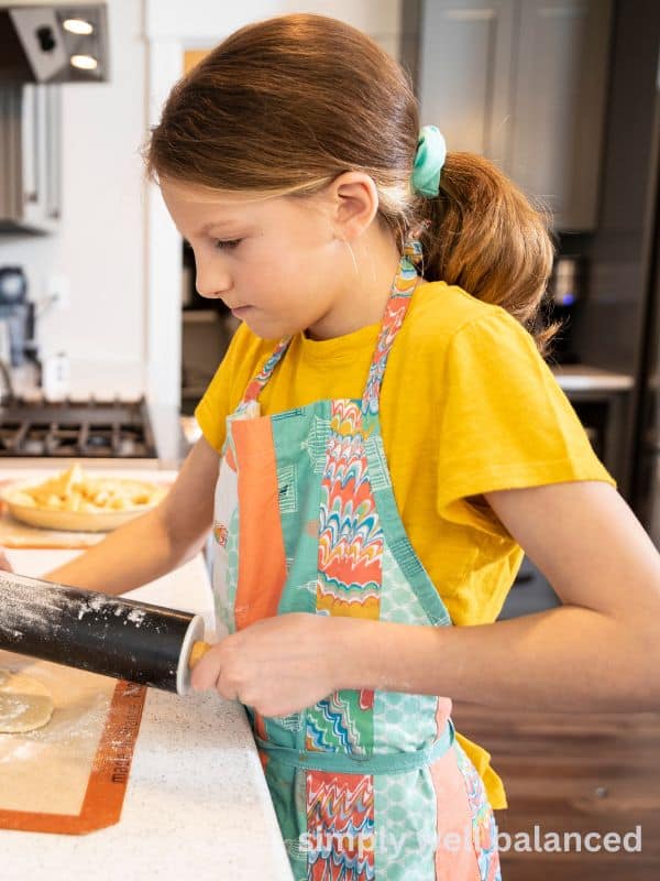 Young girl learning how to cook in the kitchen. 