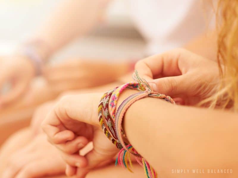 Girls wearing friendship bracelets. Making bracelets is a great activity to keep kids busy and off their devices. 