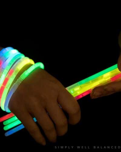 A child wearing glow stick bracelets as they prepare to play glow stick tag - a fun sleepover idea. 