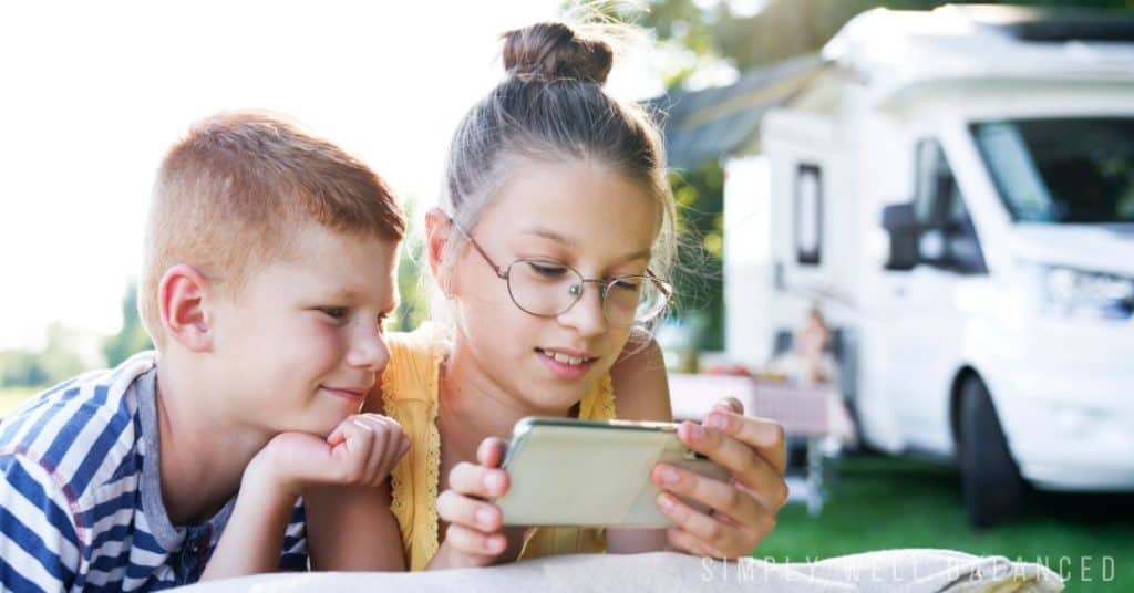 Brother and sister watching and inspiring movie on their phone. 
