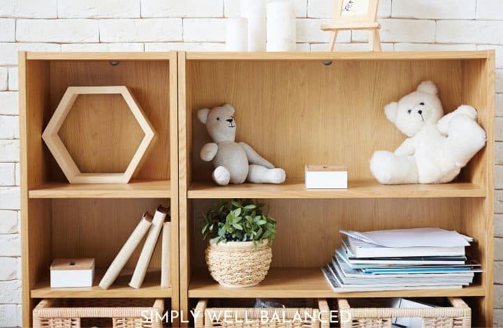A child's bookshelf, organized and decorated with toys, books, and other minimalist decor.