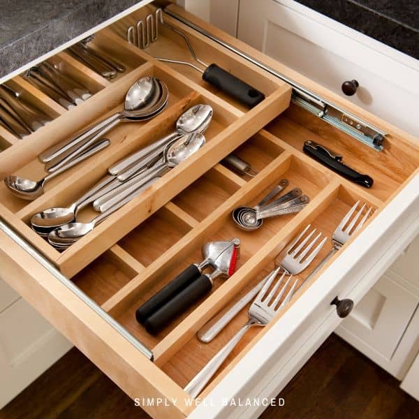 A neat and organized silverware drawer in a minimalist kitchen.