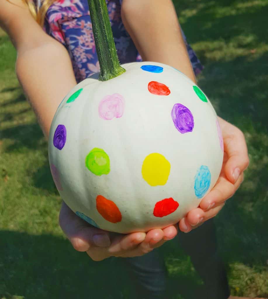 A white pumpkin painted with colorful polka dots. Fun fall activity to do with kids. 