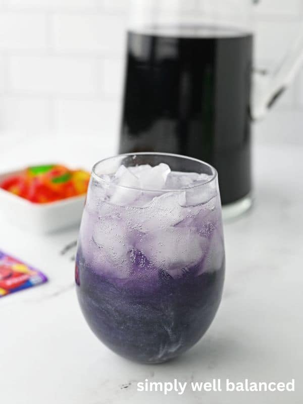 Glass full of purple punch and ice. 