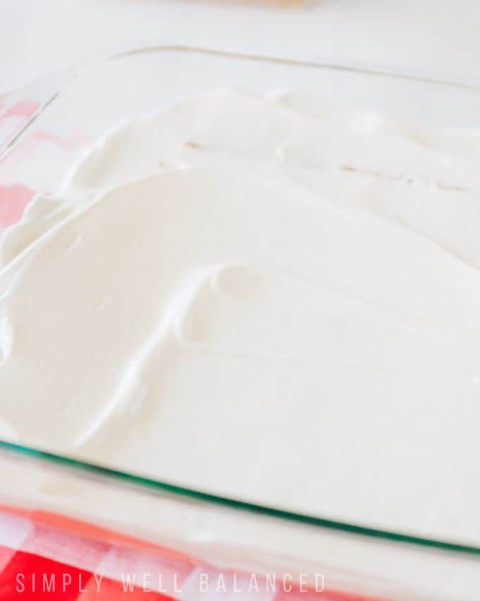 Layer of white cool whip in a 9X13 pan to make the red, white and blue icebox cake. 