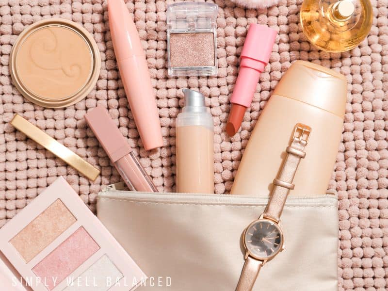The items included in a self-care gift box: lotion, lip gloss, eye shadow, perfume and lipstick. 
