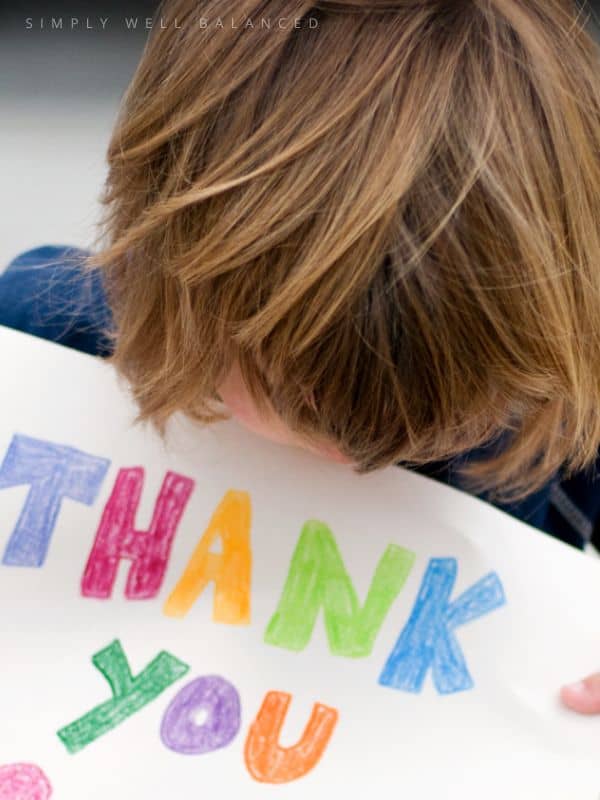 Child holding thank you sign. 