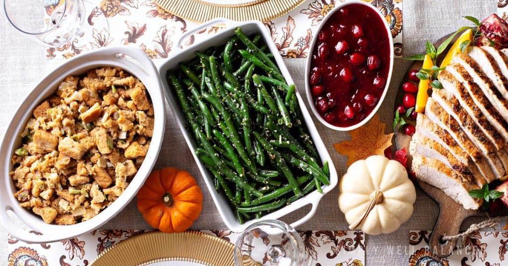 A Thanksgiving table with traditional side dish recipes that were made in the crockpot. Stuffing, green beans and cranberry sauce. 